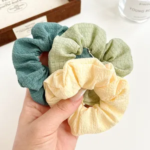 Three solid color scrunchies in yellow and green with elegant checkered texture