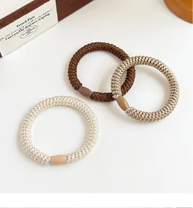 Detail of high-elastic braided hair ties in coffee tones with smooth connector beads