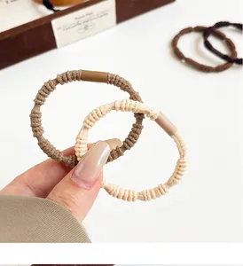 Close-up of brown elastic hair ties with spiral weave texture and secure metal buckles