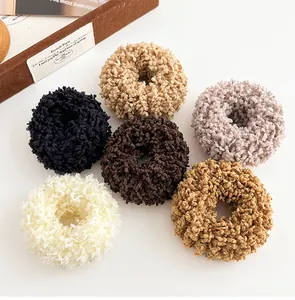 Detailed view of six fuzzy plush scrunchies in cream brown and purple fleece fabric