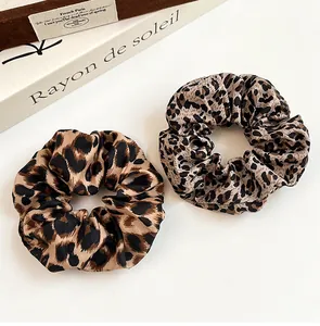 Primer plano de dos coleteros vintage con estampado de leopardo en seda elástica