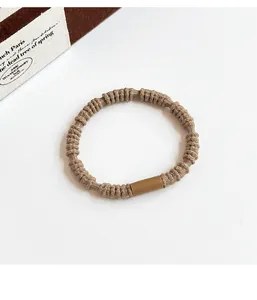 Detailed view of khaki high elasticity braided hair tie with a smooth cylindrical clasp