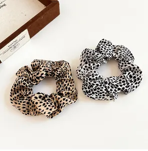 Flat lay of brown and white leopard print fabric scrunchies on a white surface