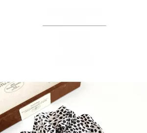 Macro detail of leopard print hair scrunchie with silky texture and black spots