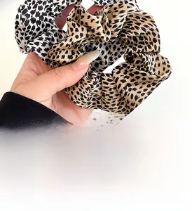 Close-up of leopard print hair scrunchies showing satin texture and elastic detail