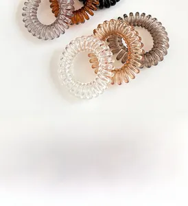 Detail von spiralförmigen Haargummis in Bernstein und Transparent mit elastischem Design