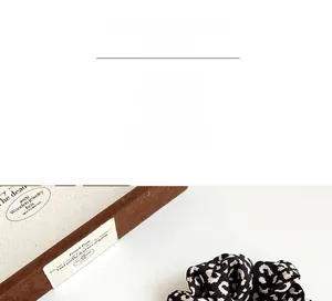 Close-up of leopard print hair scrunchie with soft fabric texture and elastic design