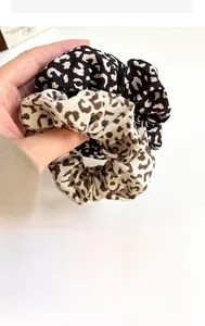 Detailed close-up of leopard print scrunchies showing fabric texture and elastic design