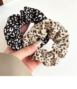 Detail of two vintage leopard print scrunchies featuring high-elastic fabric texture