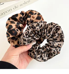 Detalle de dos coleteros con estampado de leopardo en tonos cálidos y tela elástica