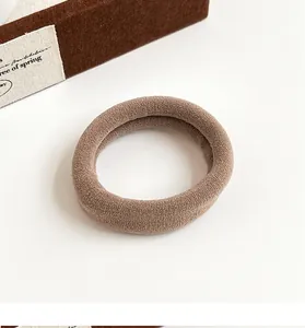 Gros plan d'un élastique à cheveux sans couture en tons terre avec texture côtelée douce