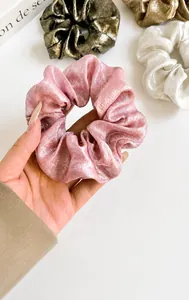 Gros plan sur des chouchous élégants en soie scintillante aux tons rose et bronze