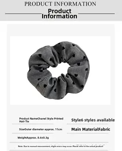 Detailed view of grey fabric scrunchie with black heart print and 11cm diameter size guide