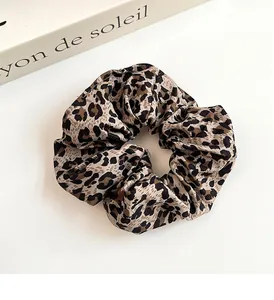 Detalle de coletero vintage con estampado de leopardo y banda elástica sobre un libro