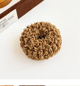 Close-up of thick brown plush hair scrunchie with soft fluffy texture and curly fabric