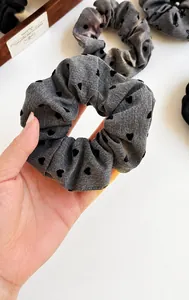 Detailed view of polka dot scrunchie with heart pattern in grey and black fabric