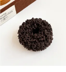 Close-up of deep coffee plush hair tie with textured fabric and elastic design