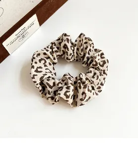 Macro shot of high-elastic scrunchie with vintage leopard print on soft pleated fabric