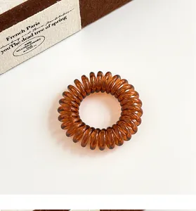 Nahaufnahme der bernsteinfarbenen Spiral-Haargummis mit transparentem Harz-Finish