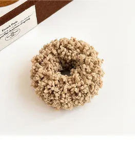Detail of plush khaki teddy fleece scrunchie with soft textured fabric for hair styling