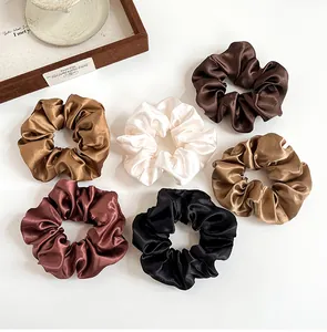 Set di sei elastici per capelli in raso nei toni della terra su sfondo bianco puro