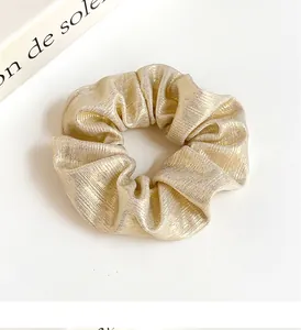 Détails de la texture plissée dorée champagne métallique de ce chouchou élégant