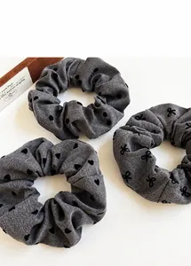 Three-piece gray scrunchie set with polka dots, hearts and bows on denim texture