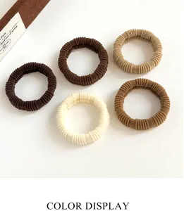 Set of five elastic earth-tone hair ties with ribbed velvet texture on white background