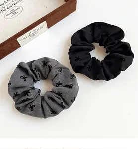 Close-up of black and grey polka dot scrunchies with elegant bow pattern and soft texture