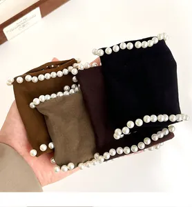 Detail of soft fabric hair scrunchies with white faux pearl trim in four earthy tones