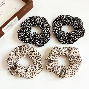 Set of four leopard print scrunchies in dark and light patterns for ponytails