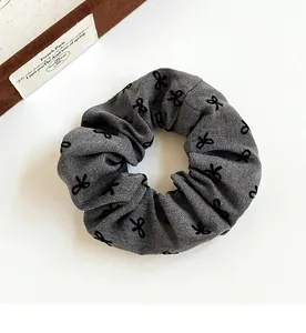 Close-up of grey and black polka dot scrunchie showing detailed cotton fabric texture