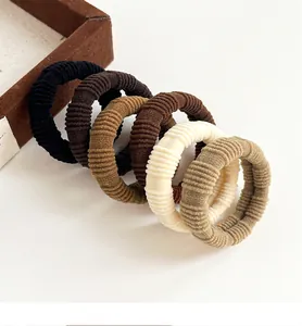 Detailed view of six ribbed elastic hair ties in neutral earthy tones and coffee shades