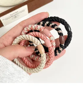 Détail d'élastiques à cheveux tressés aux couleurs Morandi avec perles ovales décoratives