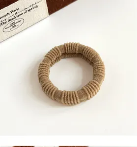 Close-up of a ribbed coffee-colored hair tie with elastic fabric and vintage texture