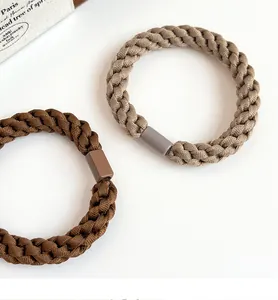 Macro detail of thick woven elastic hair ties in coffee tones with square connectors