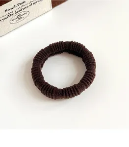 Close-up of a coffee-colored ribbed hair tie with a durable high-elasticity texture