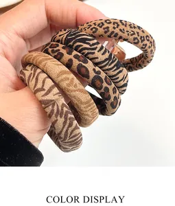 Close-up of five high-elasticity hair scrunchies with various leopard and zebra animal prints