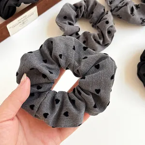 Elegant grey fabric scrunchie with black velvet hearts for bun and ponytail styling