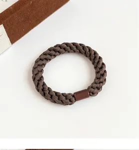 Detail of coffee brown braided elastic hair tie with durable smooth resin connector