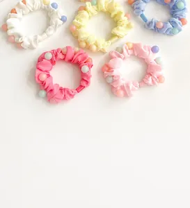 Détail de cinq chouchous plissés aux couleurs acidulées avec perles décoratives
