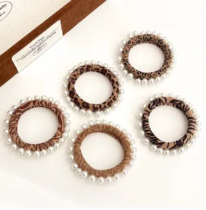 Detail of five leopard and zebra print hair ties with elegant white pearl accents