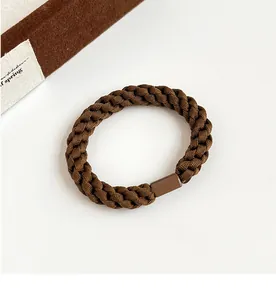 Macro shot of durable braided elastic hair tie in milk coffee brown with connector