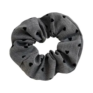 Chic grey denim scrunchie with black heart patterns and elastic ruffled texture