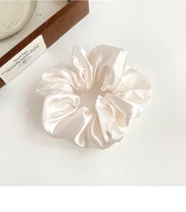 Primo piano di un grande elastico in raso bianco crema con texture di seta e pieghe eleganti