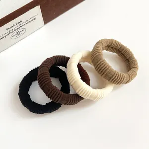 Set of 4 high-elastic coffee-colored ribbed hair ties in earthy tones on white background