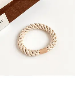 Close-up of beige woven elastic hair tie texture with a seamless plastic joint