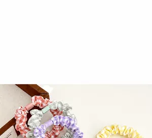 Detail of plaid scrunchies with decorative buckles in orange, green, purple, and yellow