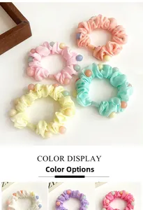Détail macro de chouchous élastiques avec perles mates colorées et tissu plissé