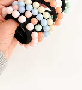 Detailed macro shot of elastic hair ties with colorful macaron pastel beads for ponytails